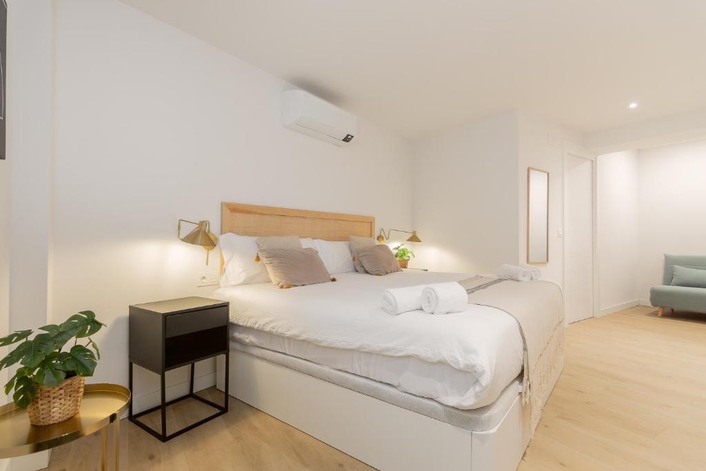 a white bedroom with a large bed and a couch at Pension Txapitela in Pamplona
