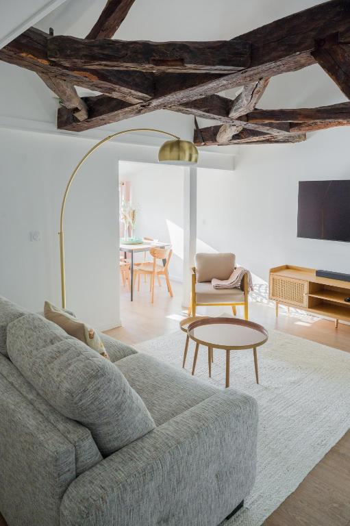 a living room with a couch and a table at Le Grand Rue Signature - Appartement coeur de ville, rue piétonne in Bergerac