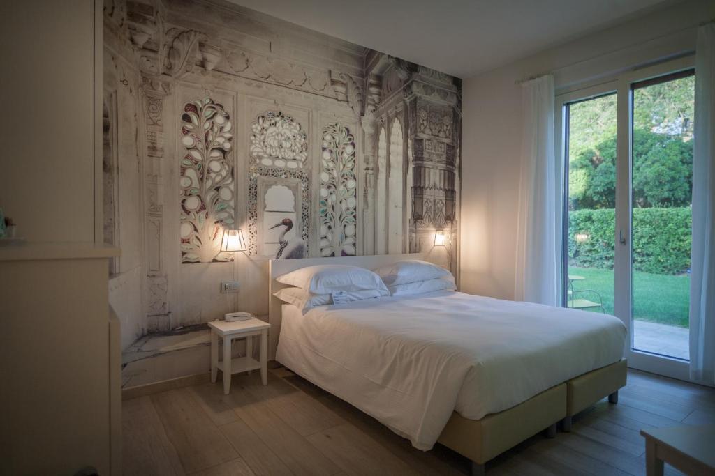 a bedroom with a bed and a large window at Arli Hotel Hideaway Punta Ala - Adults Only in Punta Ala