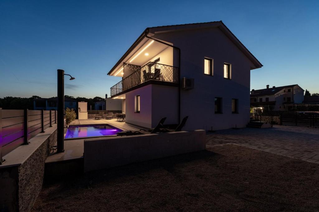 a house with a balcony and a swimming pool at Luxury-relax residence Muraj in Kornić