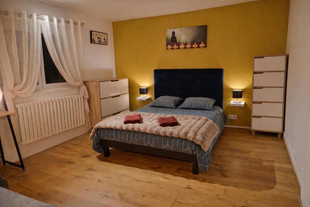 a bedroom with a bed with two red pillows on it at Maison avec jacuzzi proche Rennes jardin calme in Noyal-Châtillon-sur-Seich