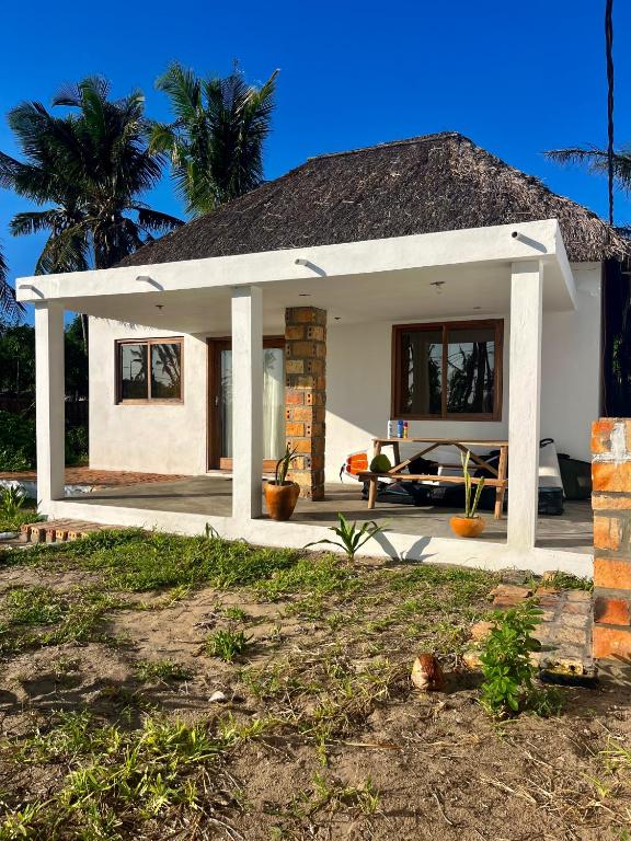 ein kleines Haus mit einem Strohdach in der Unterkunft Kategha Beach Guesthouse in Praia do Tofo
