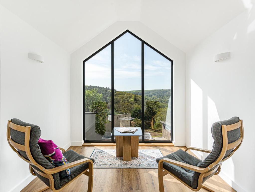 two chairs and a table in a room with a large window at Brynor Lodge in Great Torrington