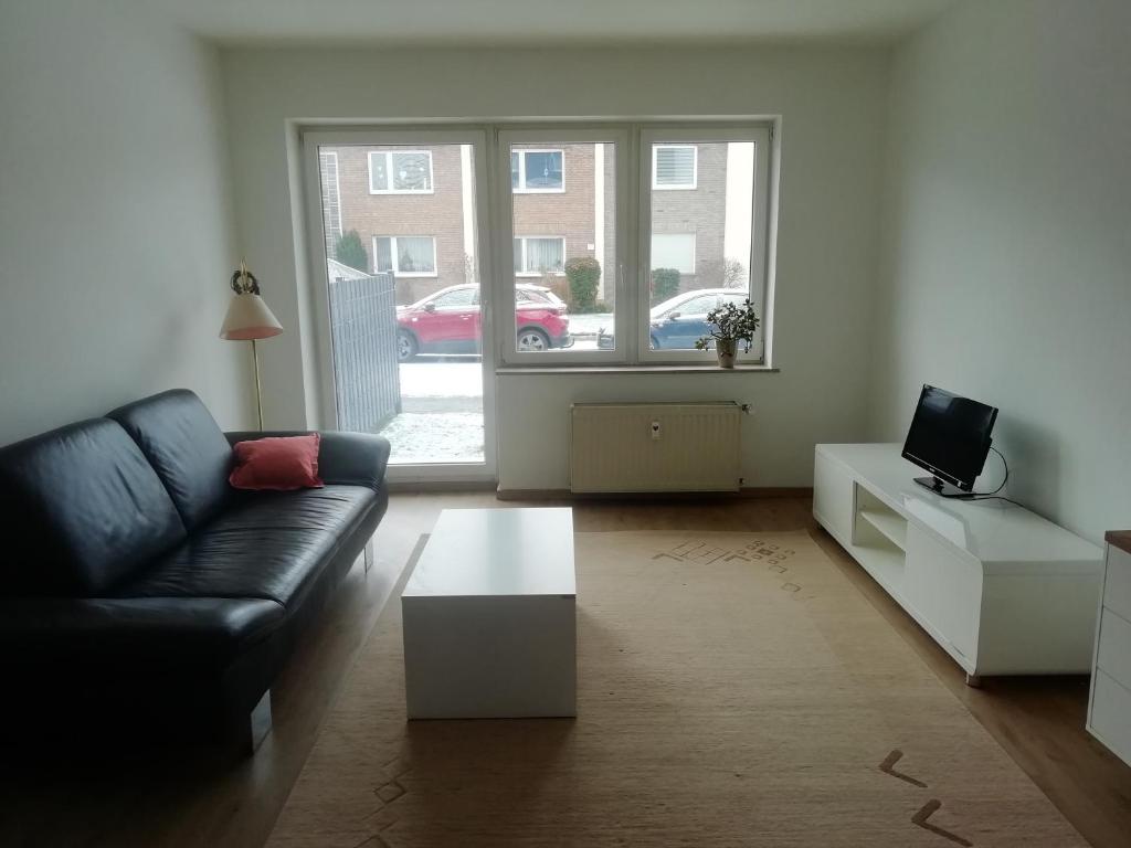 a living room with a black couch and a tv at lichtdurchflutete 2 Zimmer Wohnung in Dinslaken
