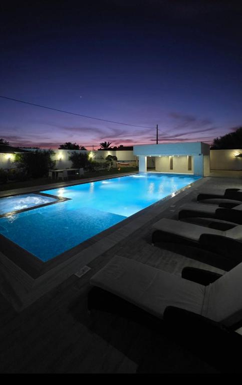 a large blue swimming pool at night at Luxury Prestige Villa in Midoun
