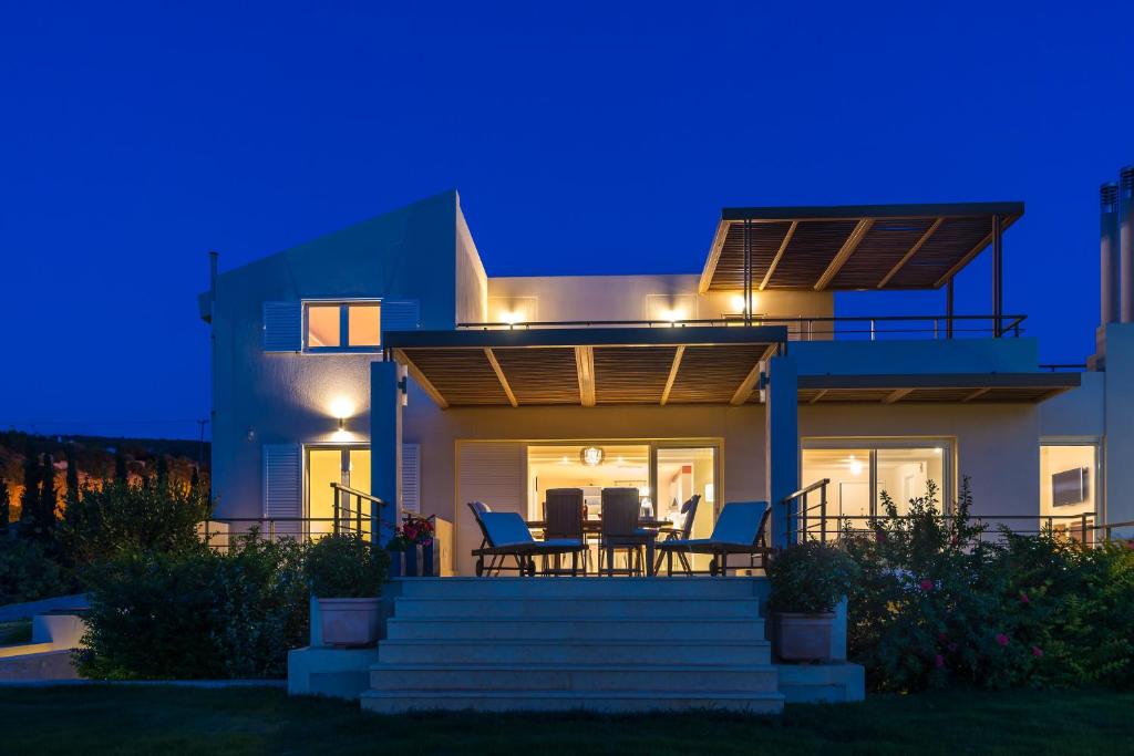 a house with a deck at night at Legrena Beach Villa in Sounio