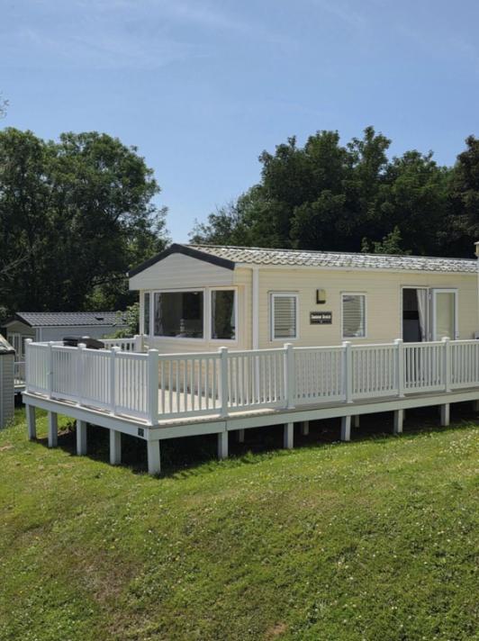 a mobile home with a porch and a white deck at Seabreeze in Goodrington