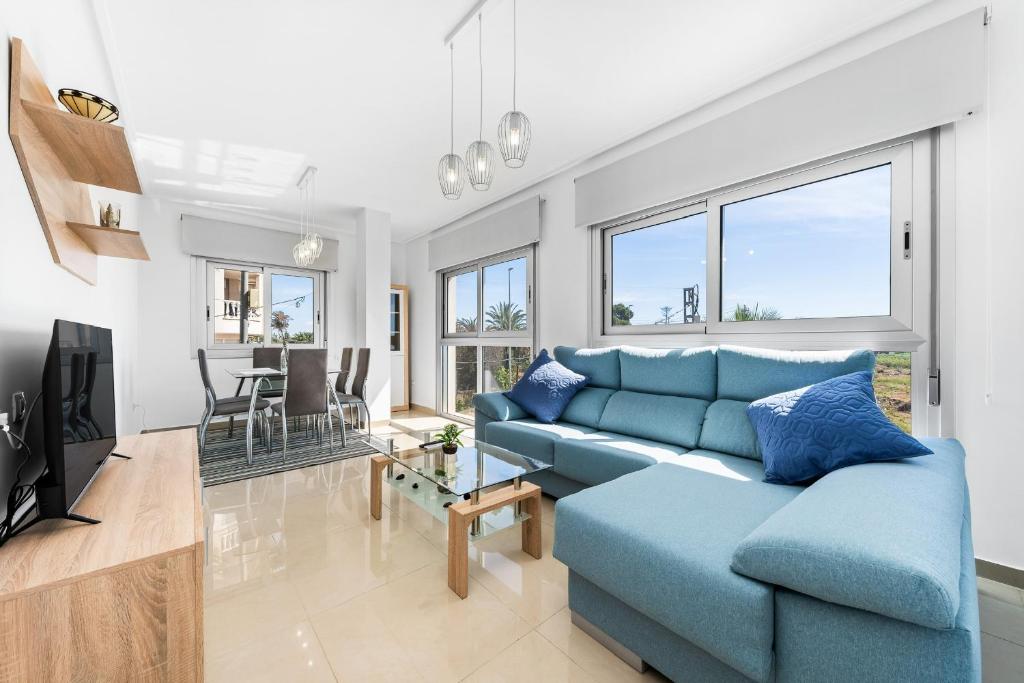 a living room with a blue couch and a tv at Aparthotel Laguna Rosa in Los Montesinos