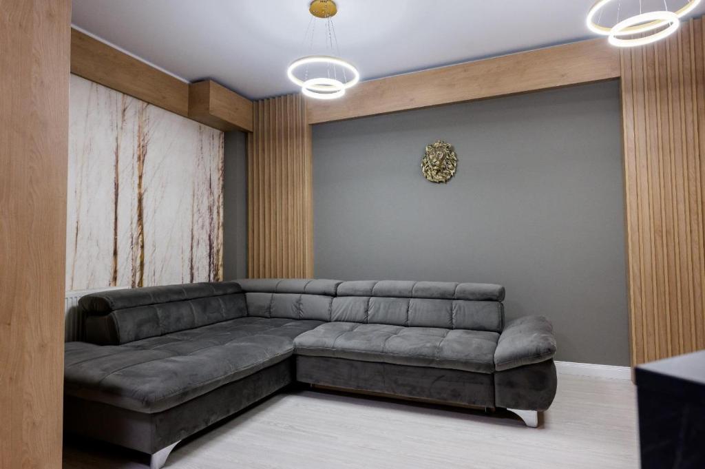 a living room with a leather couch and a wall at Apart Hotel Nordic Residence 16H in Suceava