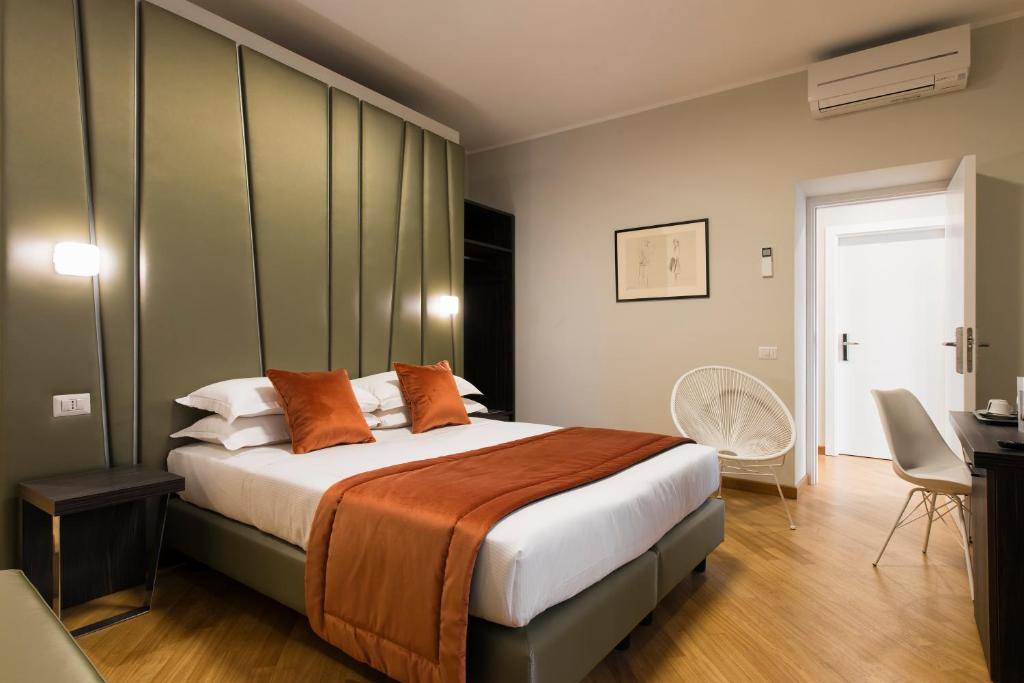 - une chambre avec un grand lit et des oreillers orange dans l'établissement Vittoriano Suite, à Rome