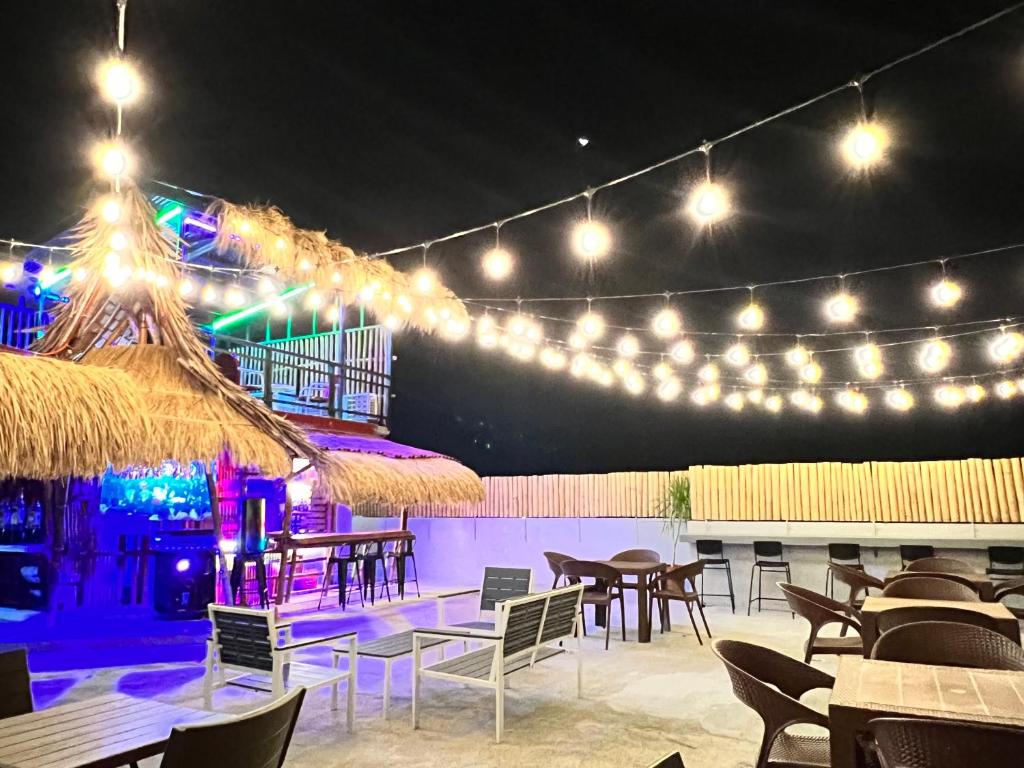 a restaurant with tables and chairs and lights at Stayhere Boracay Hostel in Boracay