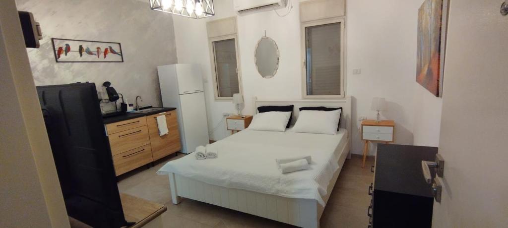a small bedroom with a bed and a refrigerator at Desert Fikus in Beʼer Ora