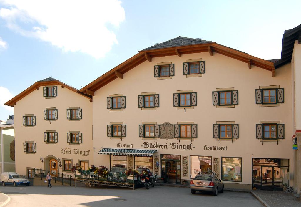 duży biały budynek z czarnymi oknami w obiekcie Hotel Binggl w mieście Mauterndorf