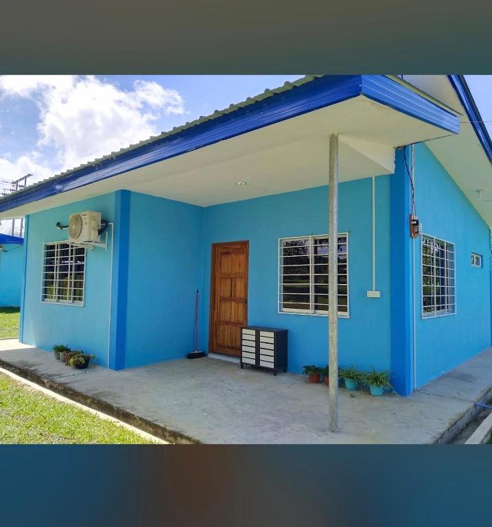 a blue house with a wooden door and windows at KRPV Homestay in Tambunan