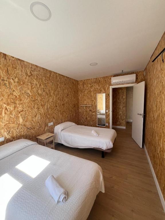 a room with two beds in a room with a wall at Casa Bubela - Vía de la plata in Dozón