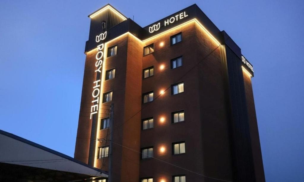 a building with a sign on the side of it at Cheonan Asan Rosy Hotel in Asan