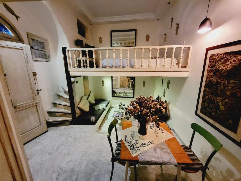 a dining room with a table with a vase of flowers at Mediterranean Breeze Studio in Sidi Bou Saïd