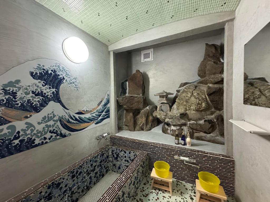 a bathroom with a wave mural on the wall at 姫路城下町 巡 in Himeji