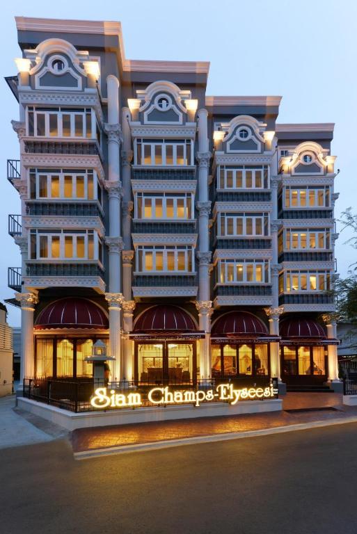 a tall building with a sign in front of it at Siam Champs Elyseesi Unique Hotel in Bangkok