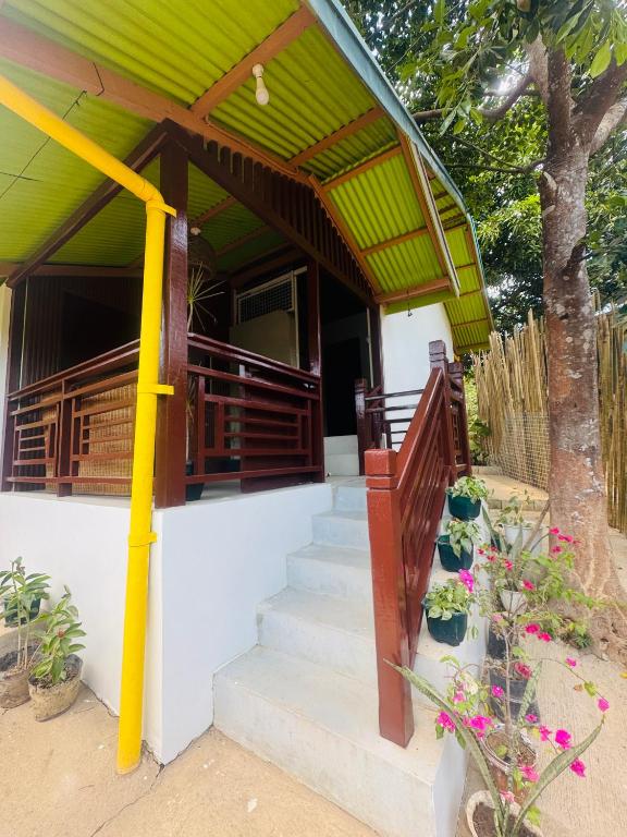 a house with stairs and a green roof at Gabs Haven Transient House in El Nido