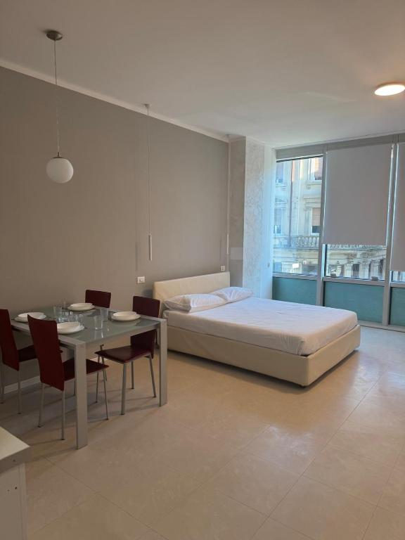 a bedroom with a bed and a table with chairs at Duca d Aosta apartment 2 in Monfalcone