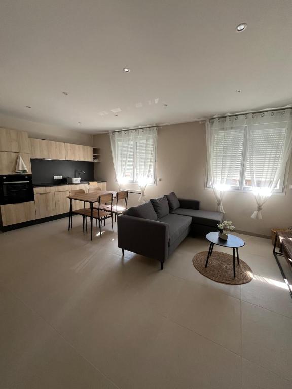 a living room with a couch and a table at Le Cosy in Saint-Marcellin