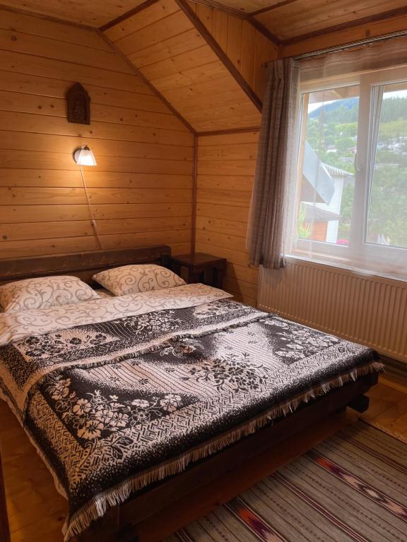 a bedroom with a bed in a room with a window at Chalet Rovenka in Verkhovyna