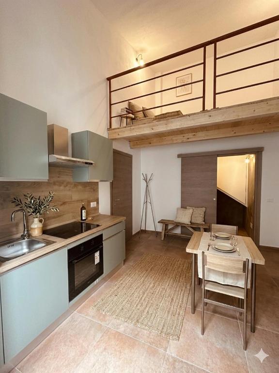 a kitchen with a table and a kitchen with a loft at Be Local-Avola stay in Avola