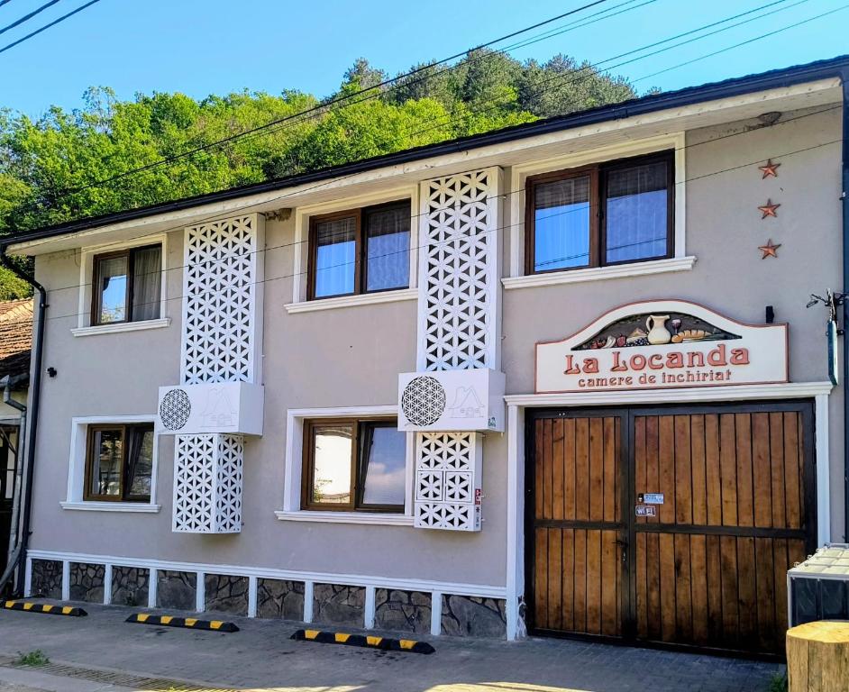 a building with a sign that reads la loonda center of excellence at Camere de inchiriat La Locanda in Dubova