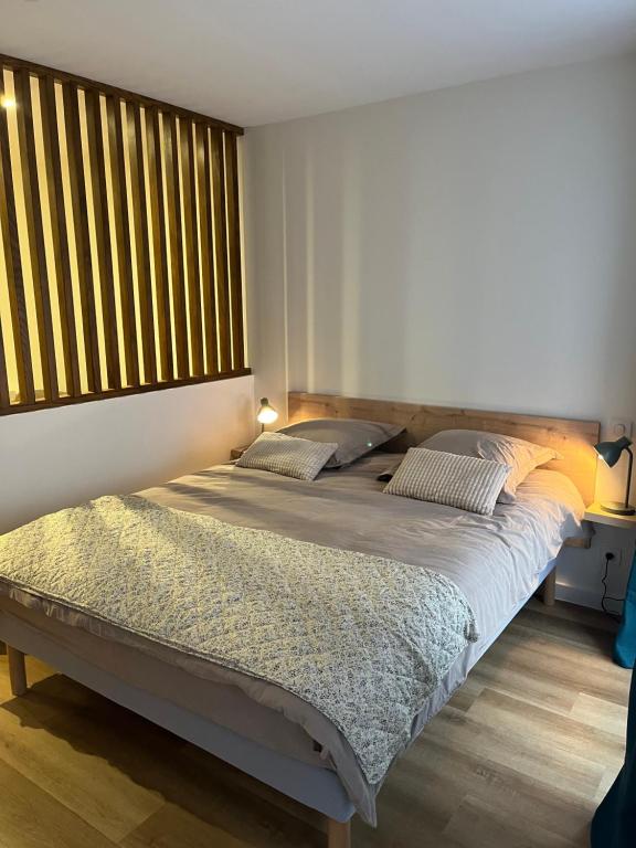 a bedroom with a large bed with a large window at Charmant studio au coeur du centre ville historique - Les tailleurs in Sélestat