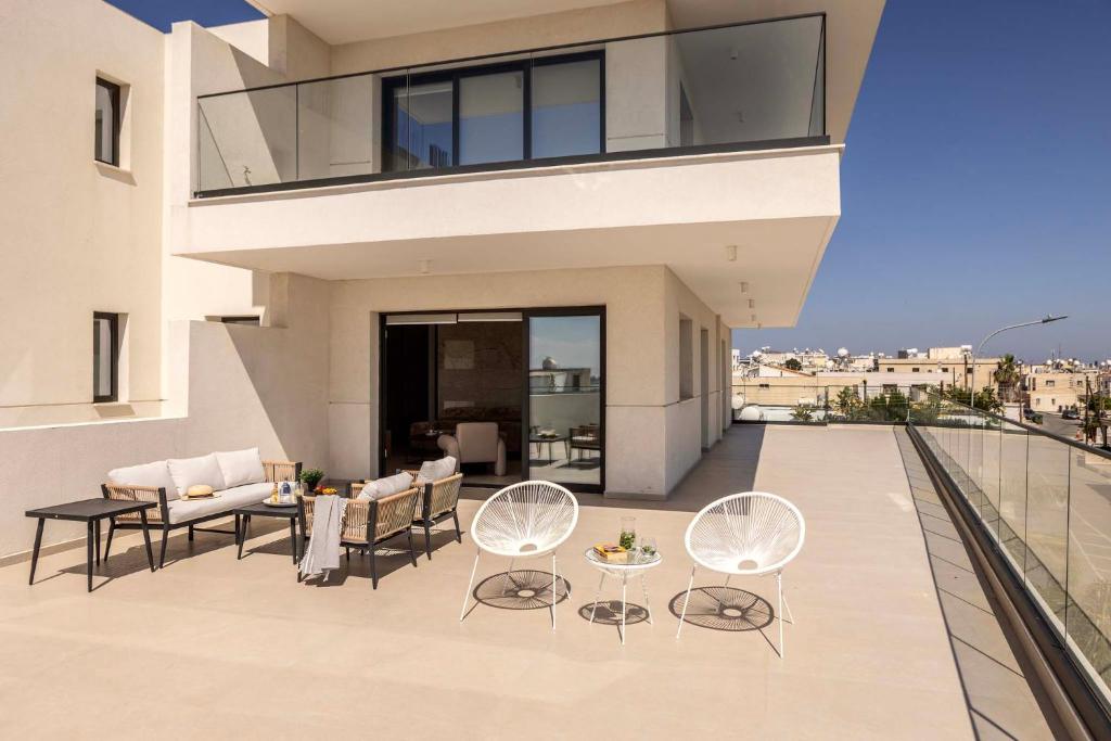 a balcony of a house with chairs and tables at Lake View Suites in Paralimni