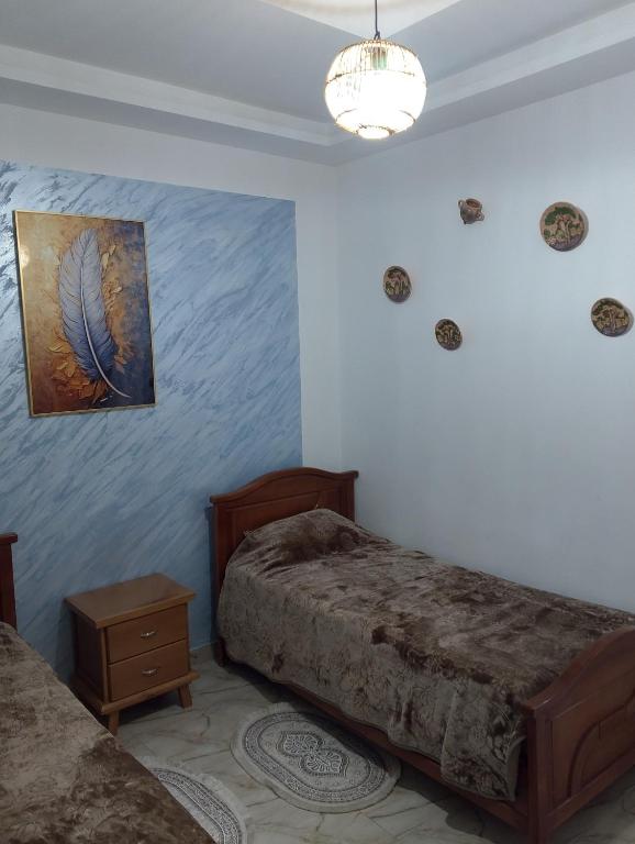 a bedroom with two beds and a painting on the wall at Moussaoui house in Aïn Draham