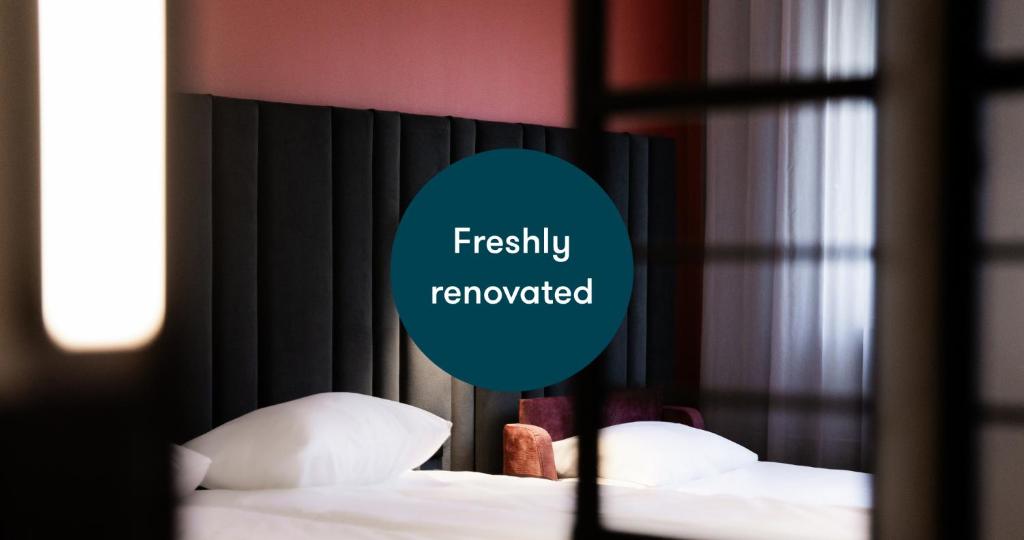 two beds in a hotel room with a sign that reads freshly renovated at Tallink Express Hotel in Tallinn