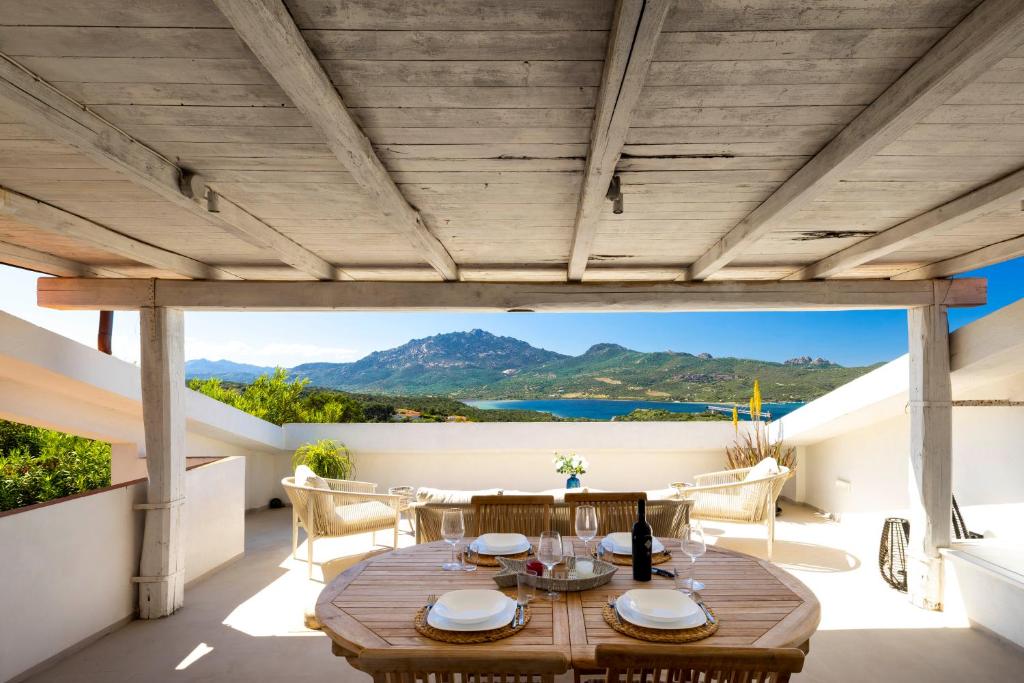 an outdoor patio with a wooden table and chairs at MH Suites in Olbia