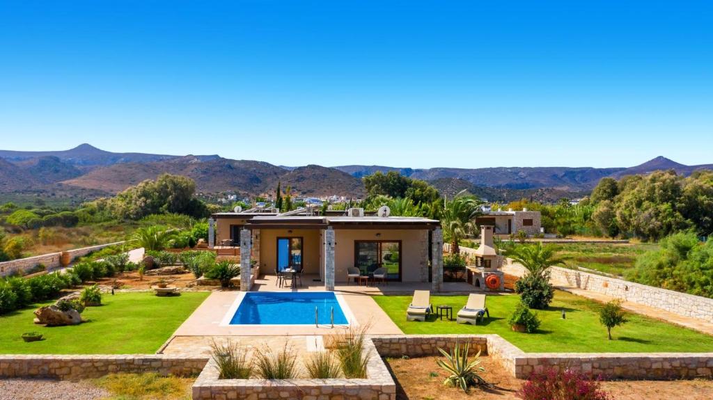 a villa with a swimming pool and a garden at Muses Beach Villas - Urania in Sitia