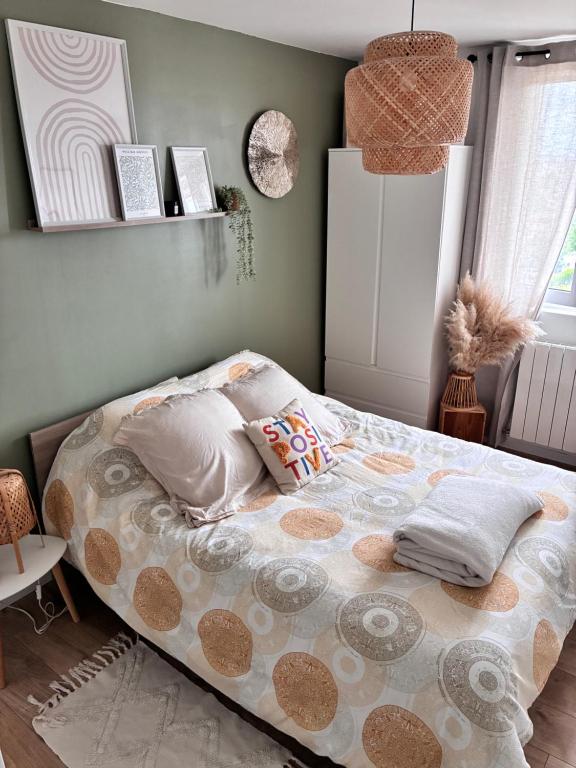 a bedroom with a bed with pillows on it at Appartement Cosy Beauvais in Beauvais