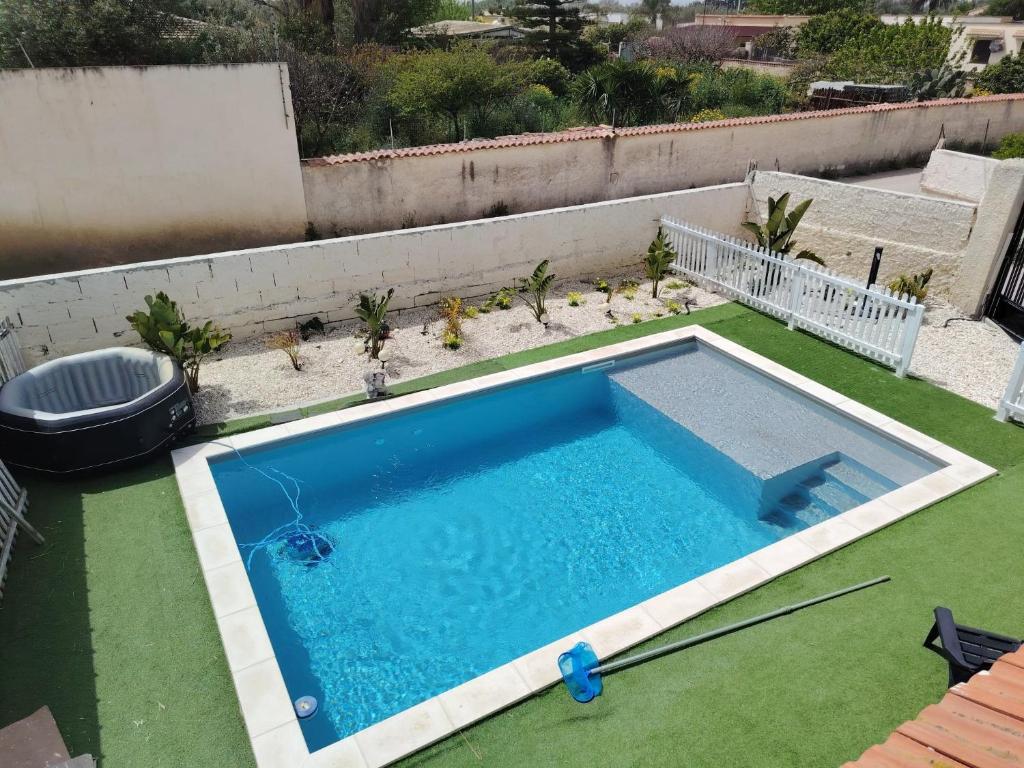 an empty swimming pool on a yard with green grass at Villa Ohana in Syracuse