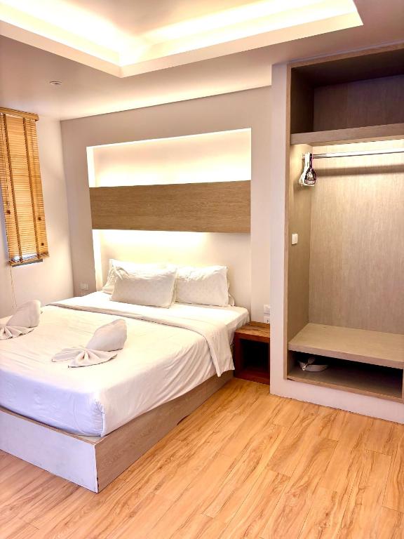 a bedroom with a large white bed and a mirror at Breezy Studio Aonang in Ao Nang Beach