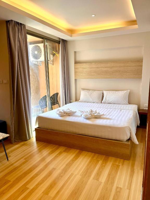 a bedroom with a bed with white sheets and a window at Adventure Studio Aonang in Ao Nang Beach