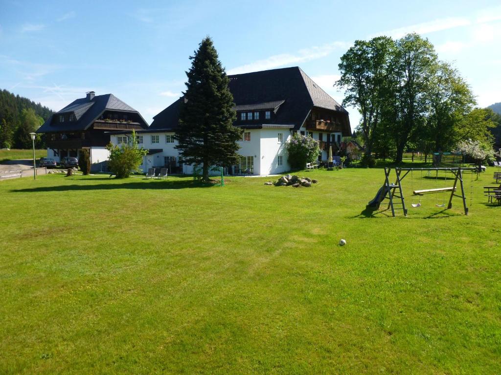 ein großer Hof mit einem Haus und einem Baum in der Unterkunft Hermeshof und Biohaus in Titisee-Neustadt
