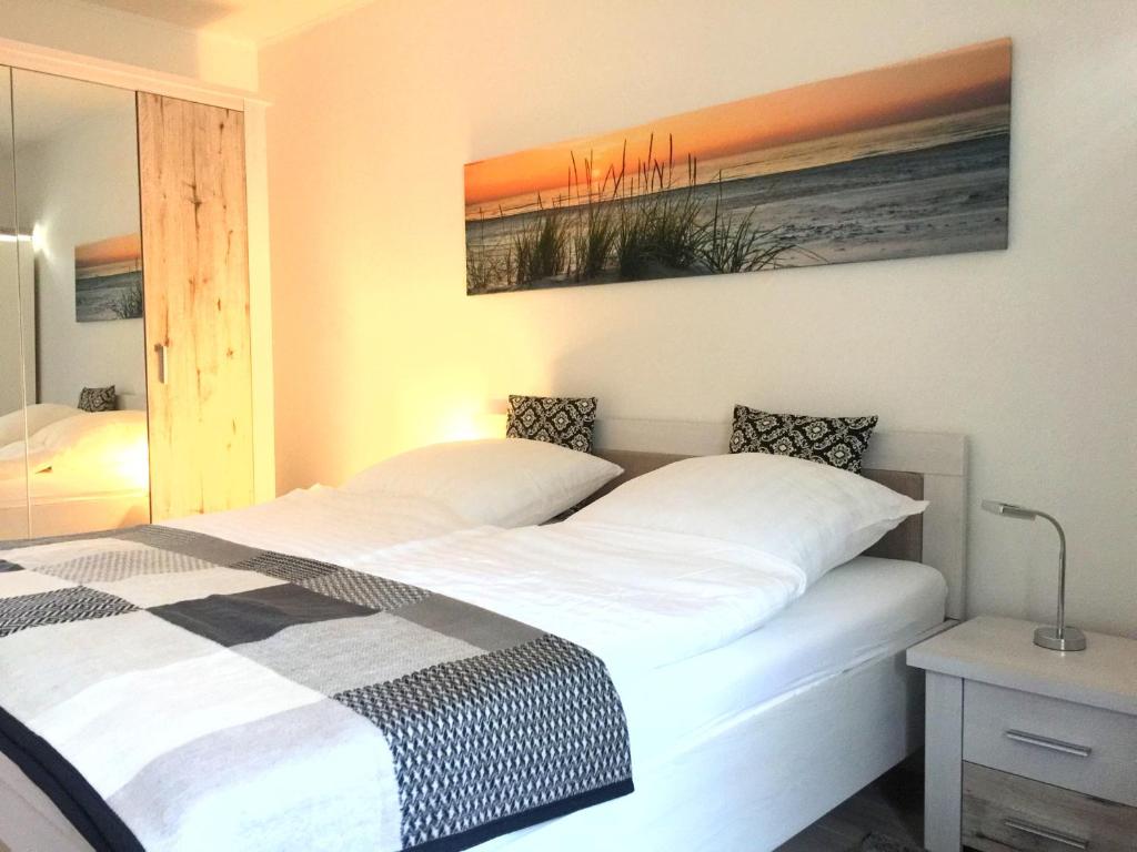 ヴァーネミュンデにあるApartment Warnemünde 16のベッドルーム1室(ベッド2台付)が備わります。壁には絵画が飾られています。