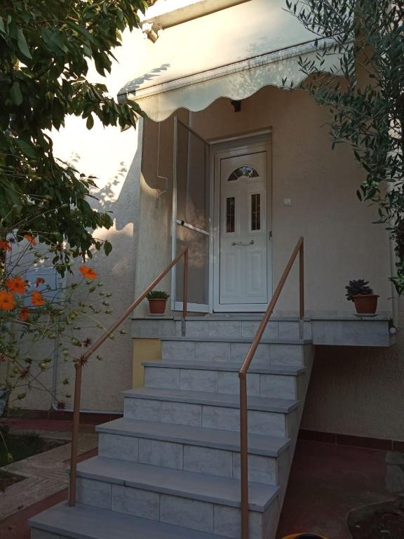 a staircase leading to a house with a white door at Rodi Home in Sotíra