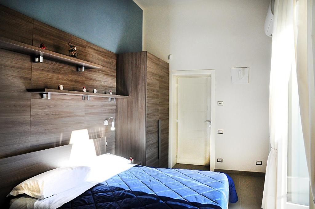 a bedroom with a blue bed and wooden wall at Casa Amato in Naples