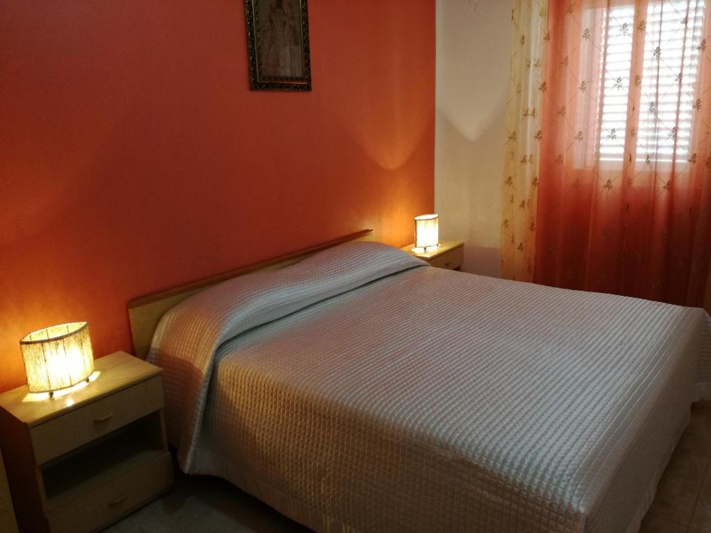 ランペドゥーザにあるMare e Sole Holiday Homeのベッドルーム1室(ベッド1台、テーブルにランプ2つ付)