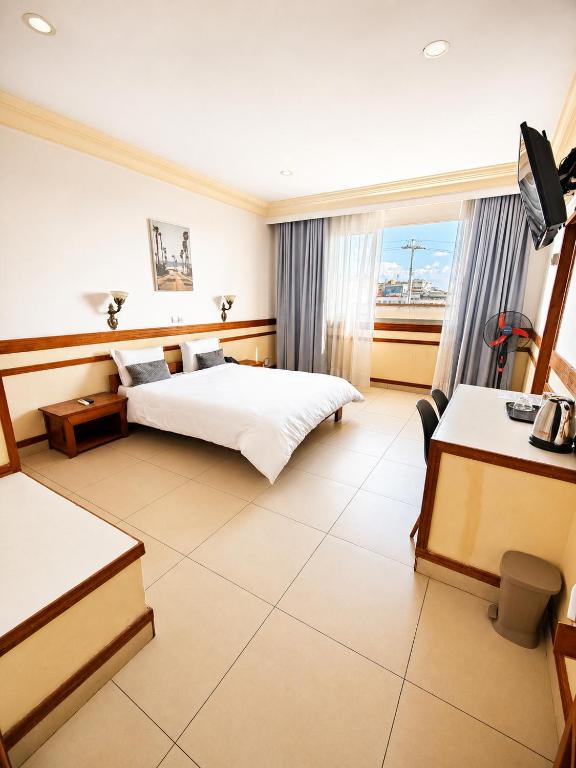 a hotel room with two beds and a window at Hôtel Shalimar in Antananarivo