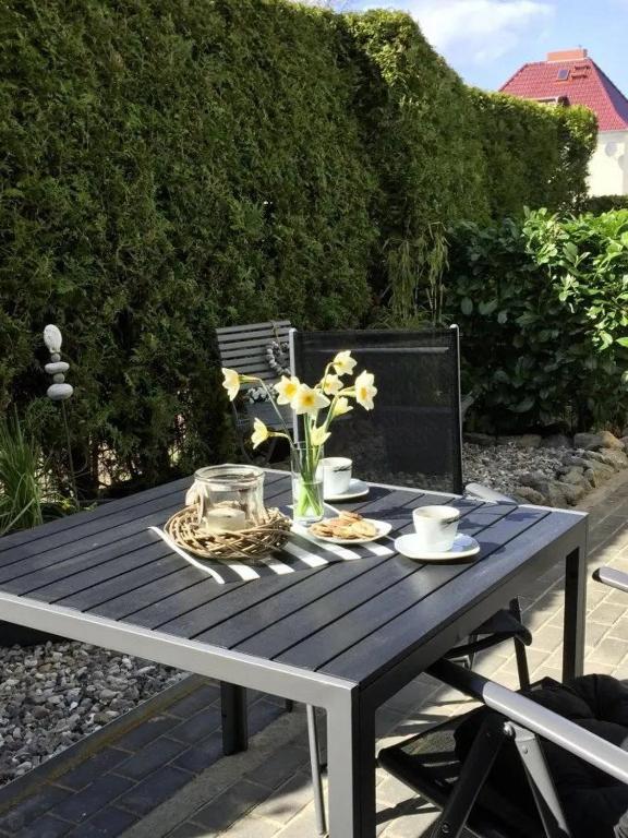 a picnic table with a vase of flowers on it at Ferienwohnung Strandgut im Ostseebad Baabe in Baabe