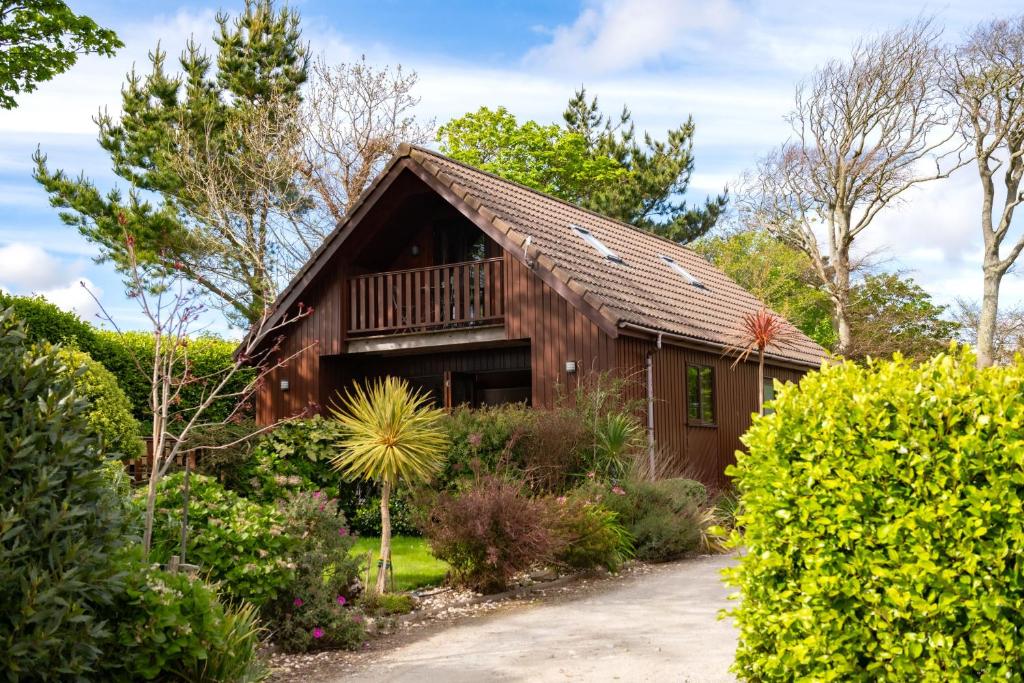 a wooden barn with a balcony in a garden at E40 - Kiberick in Truro