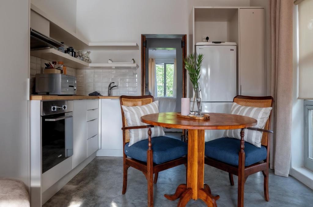 a kitchen with a table and chairs and a refrigerator at Eunoia Cottage in Paarl
