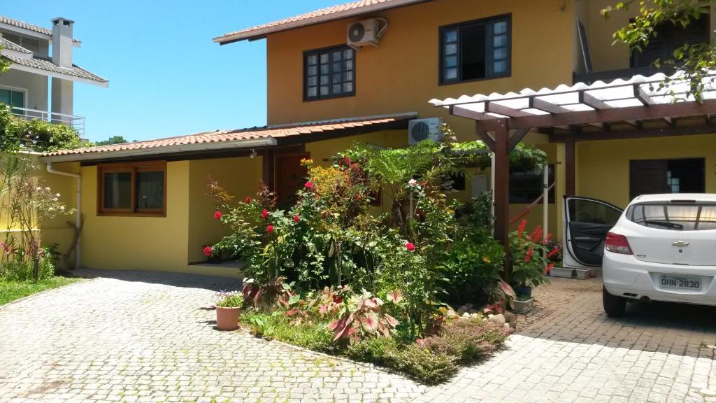 a car parked in front of a house with flowers at Casas na Praia de Bombas - Bombinhas in Bombinhas
