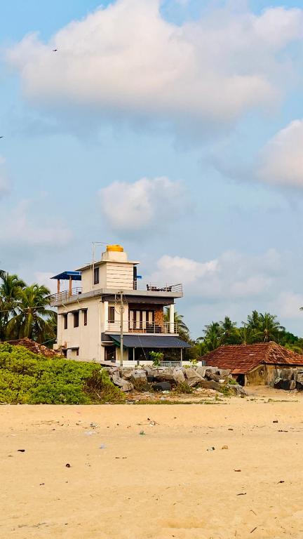 a house sitting on the beach next to the ocean at Eevara Beach By Shore in Kaup